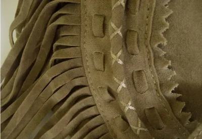 شراشيب من جلد الغزال مائلة عبر العبوة
